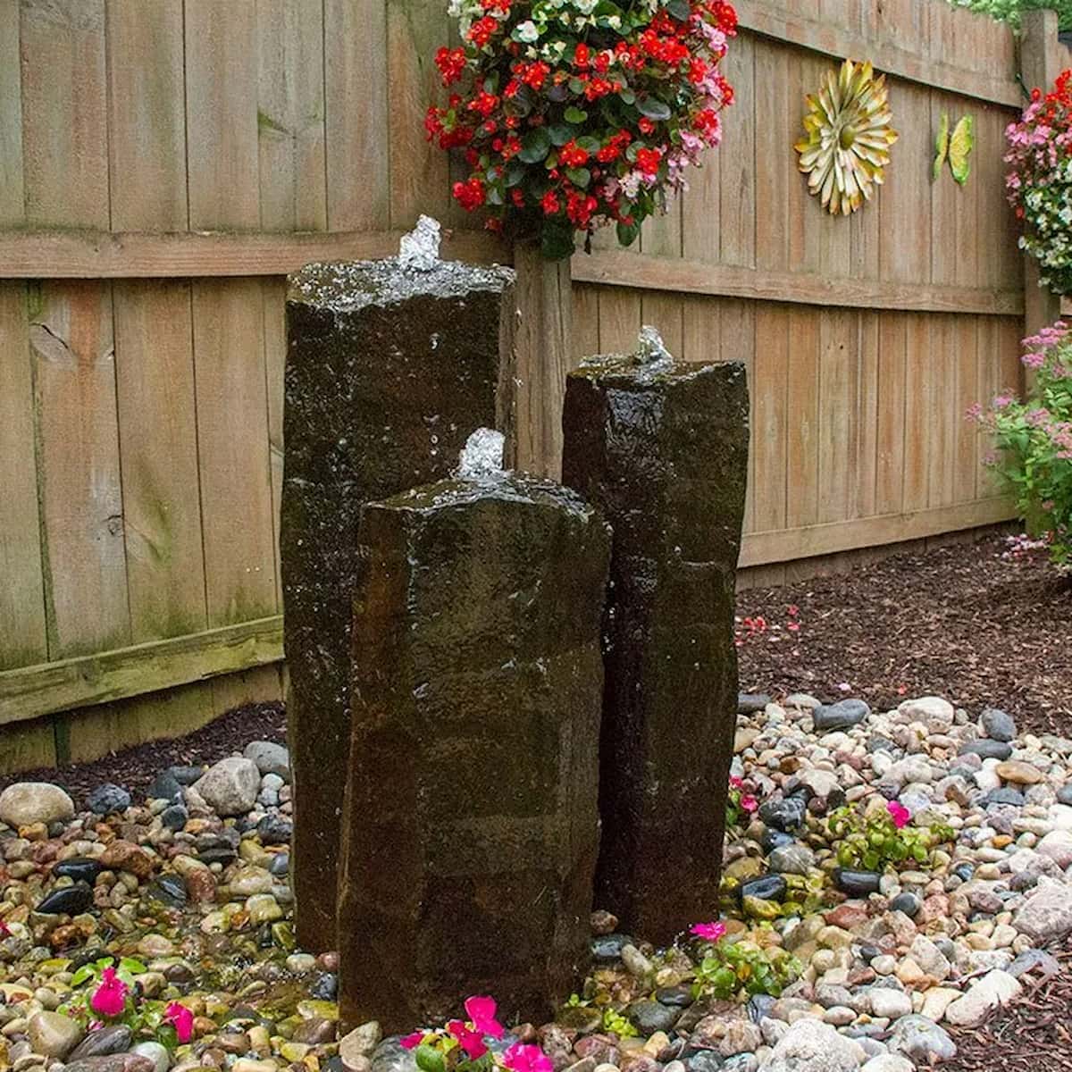 Three stone fountains in a garden with flowers. - 3 stone basalt