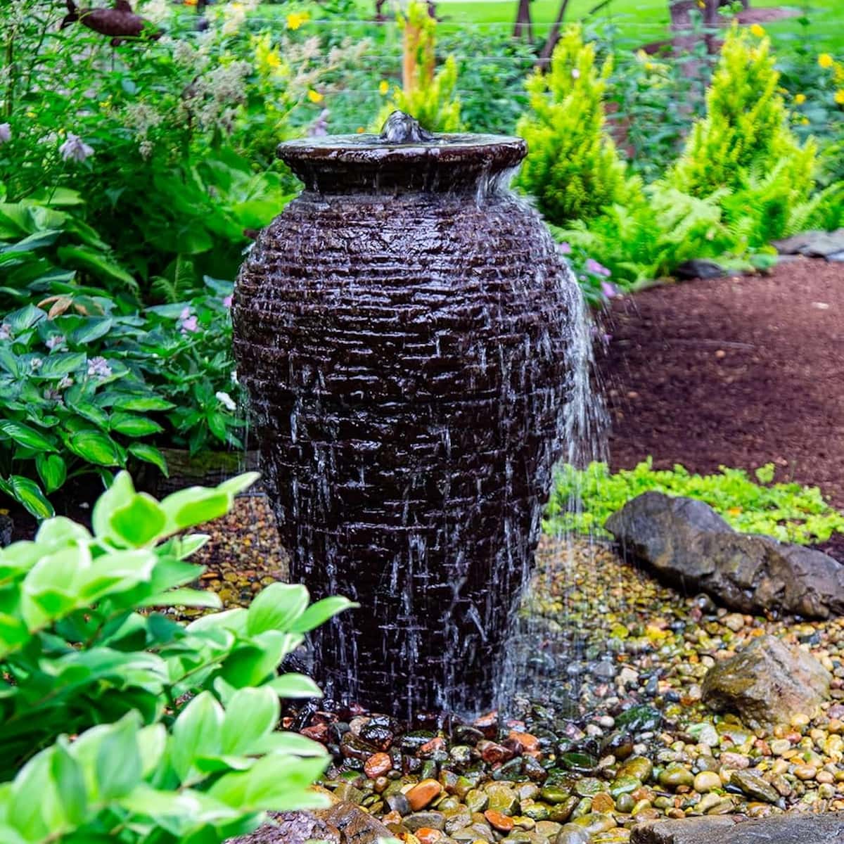 Water flowing over a garden jar fountain. - Stacked Slate Urn Fountain Kit – 45″ H (114 cm)