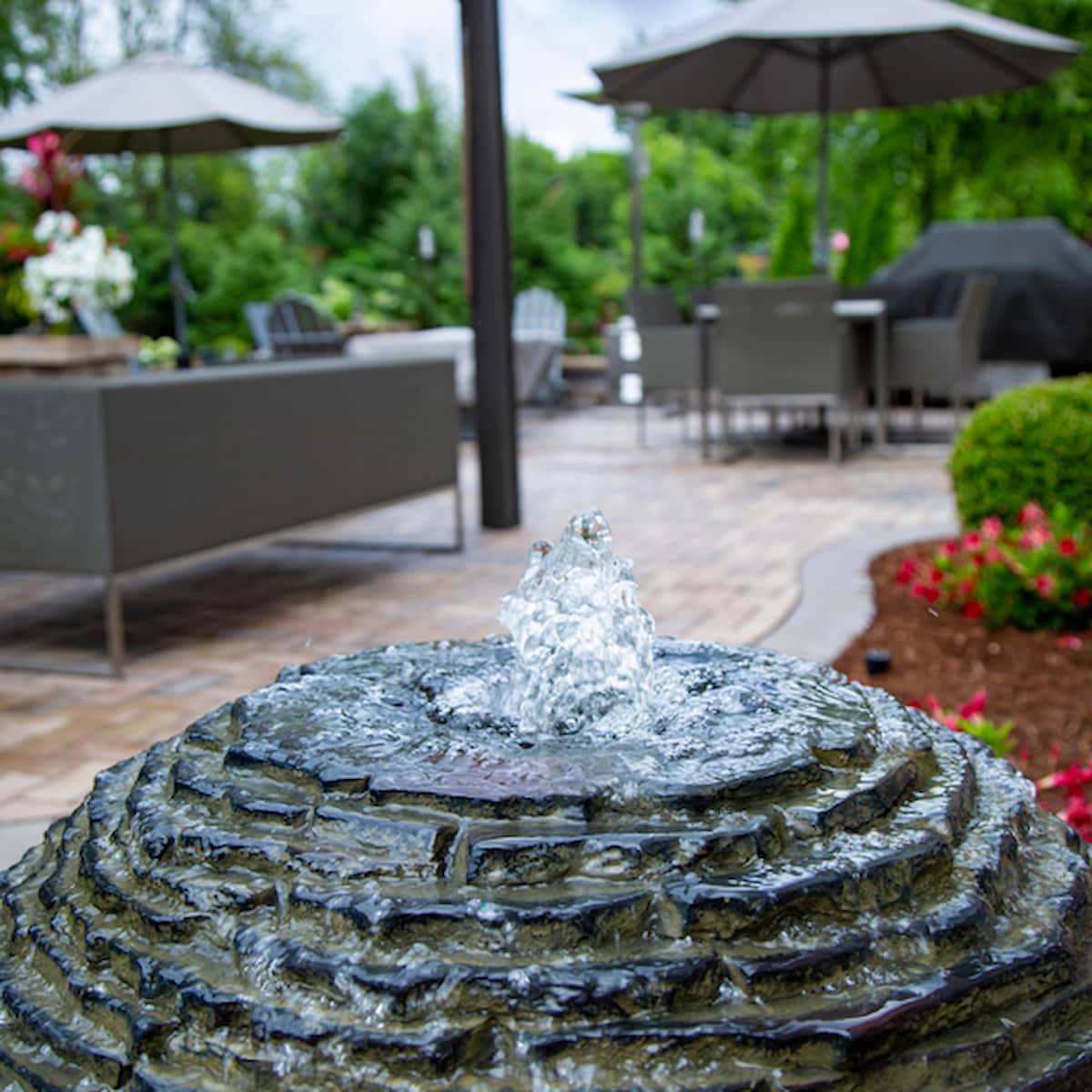 Stone fountain in a landscaped patio garden. - Stacked Slate Sphere Fountain Kit – 32″ Dia (81 cm)